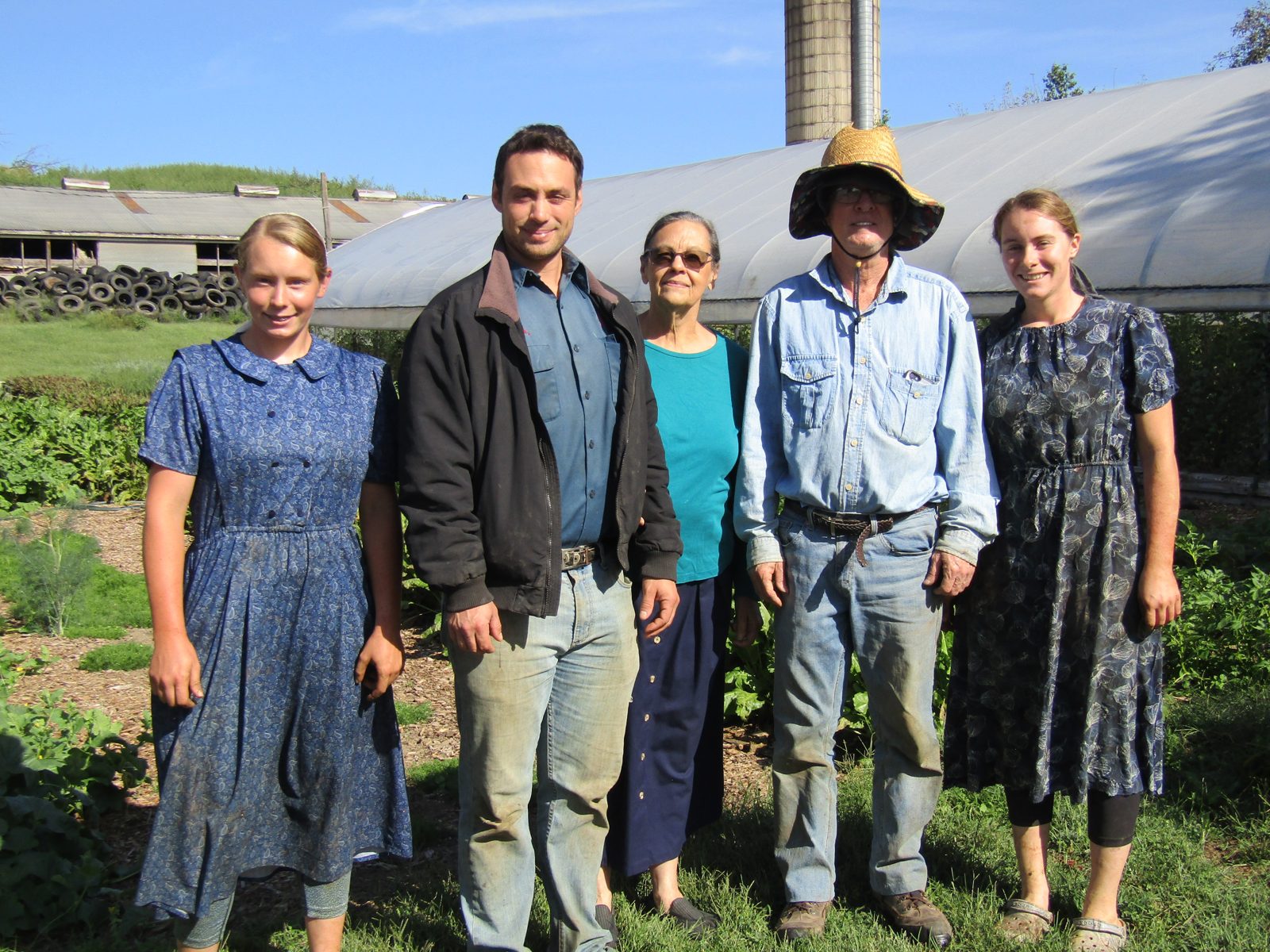 The Wayside Produce Farm family standing together in front of the greenhouse